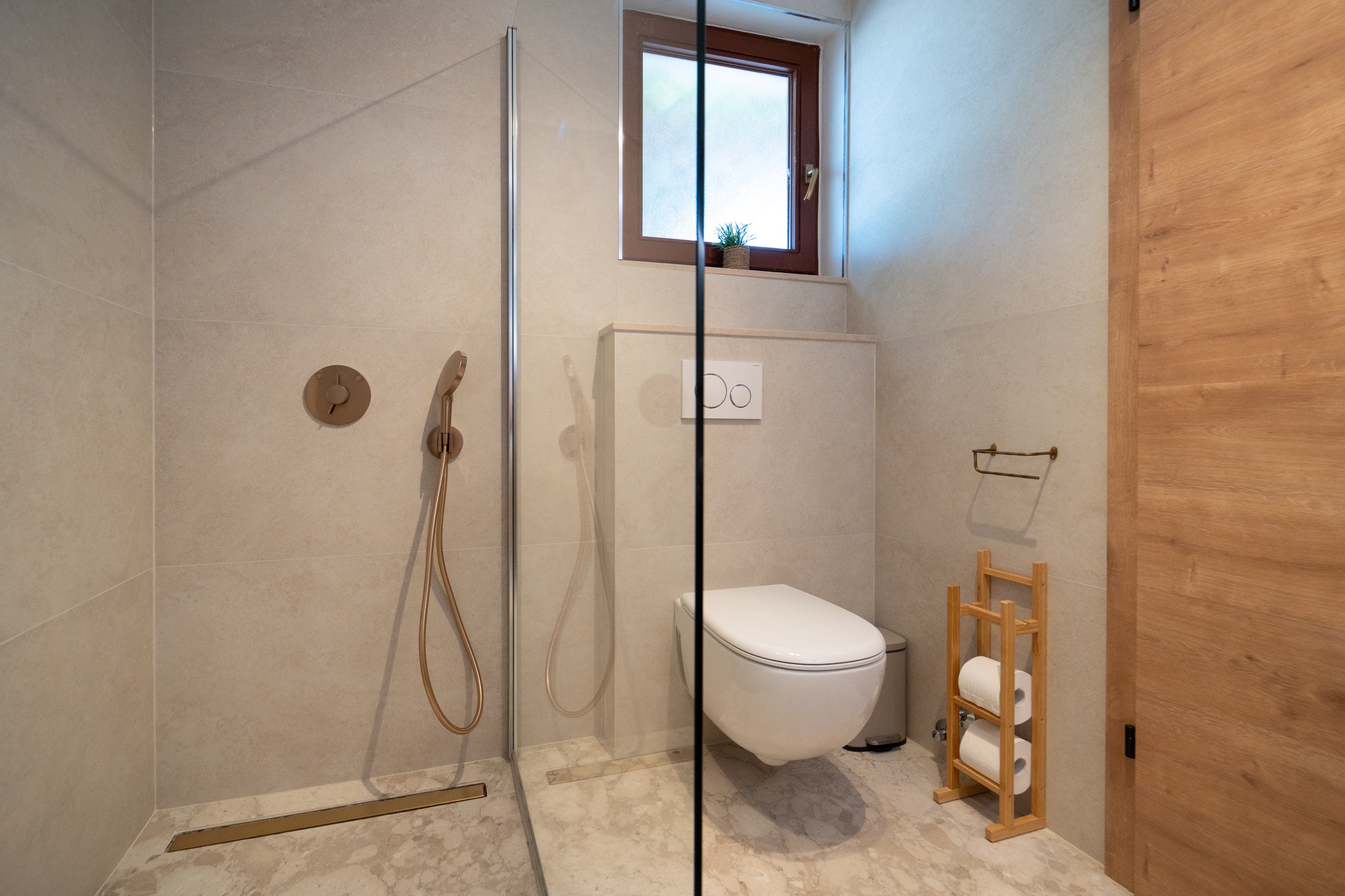 Bagno in pietra neutro a Villa Lostura con cabina doccia e WC separato