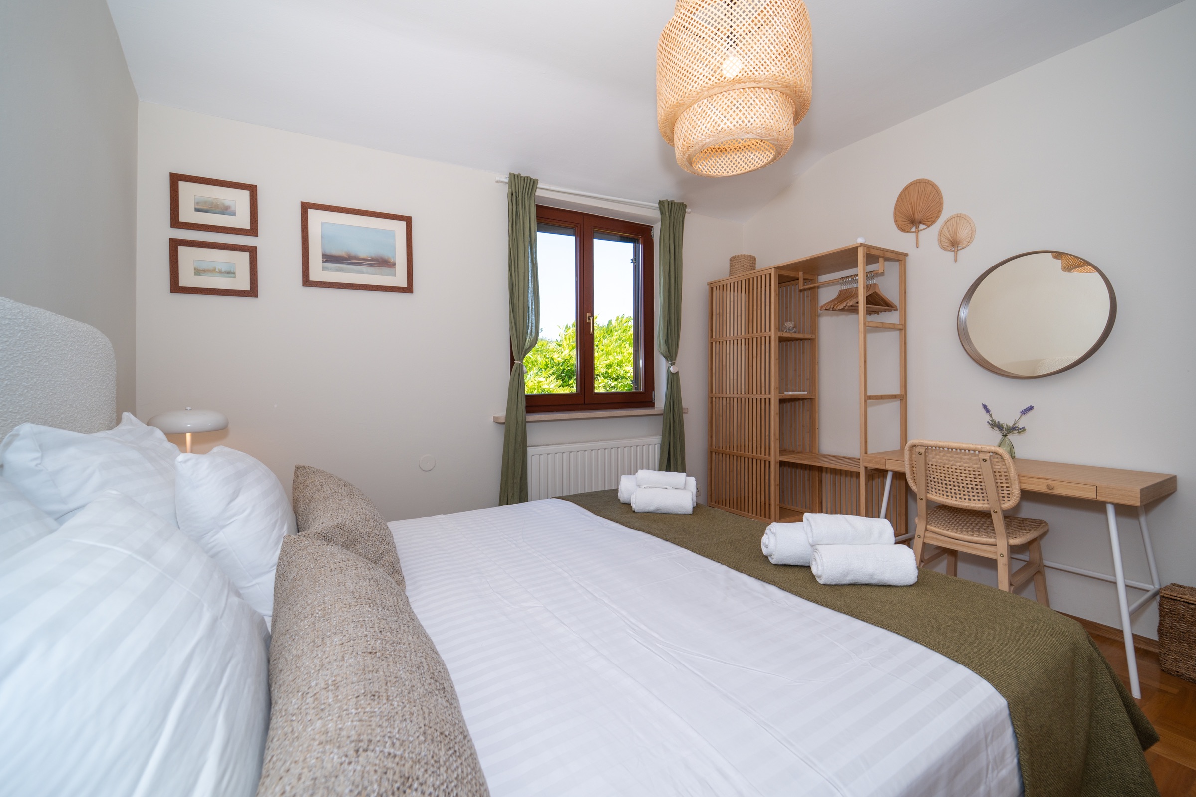 Prima camera da letto matrimoniale verde con tessuti di oliva, una scrivania e dettagli tessuti naturali