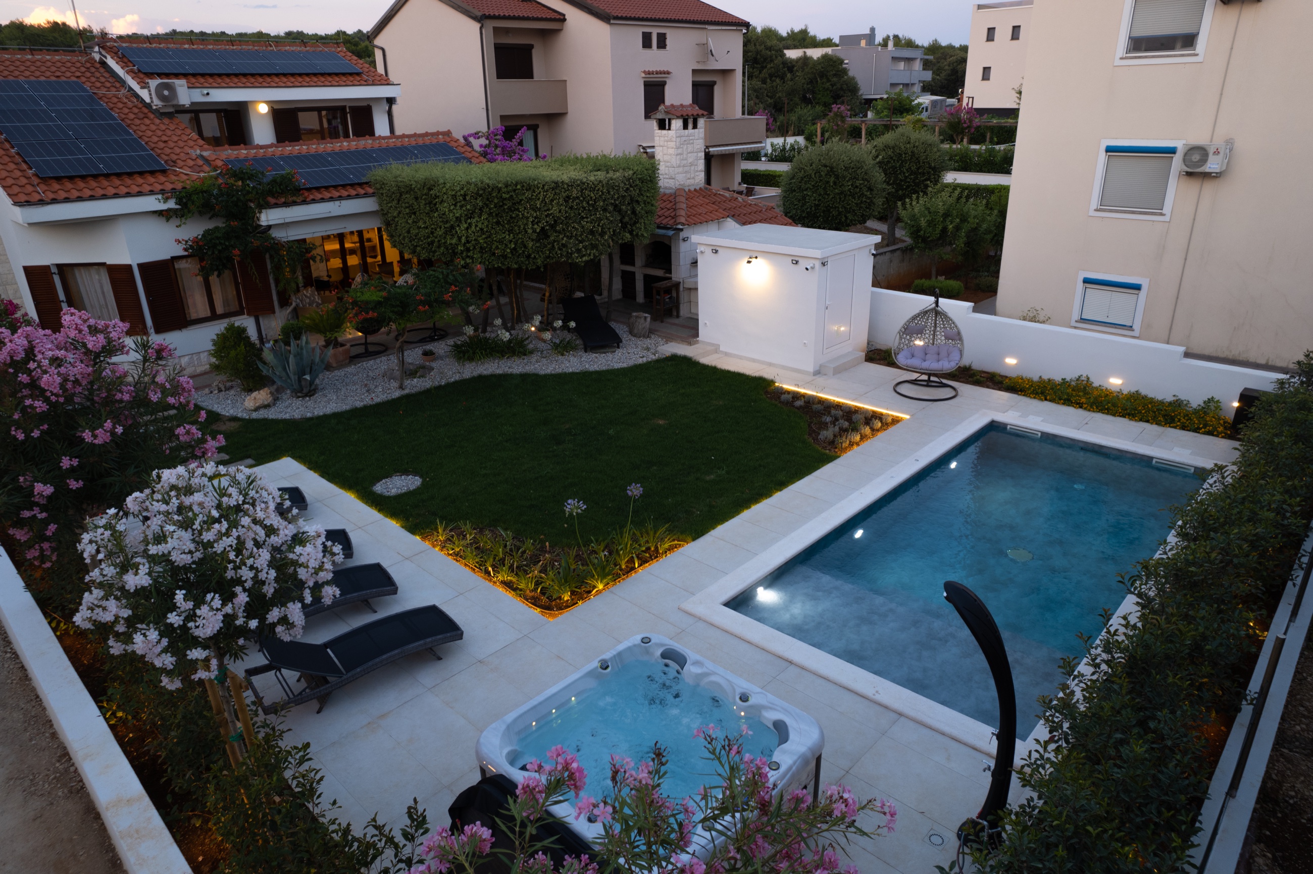 Villa Lostura in der Abenddämmerung mit beleuchtetem mediterranen Garten, privatem Pool und Whirlpool